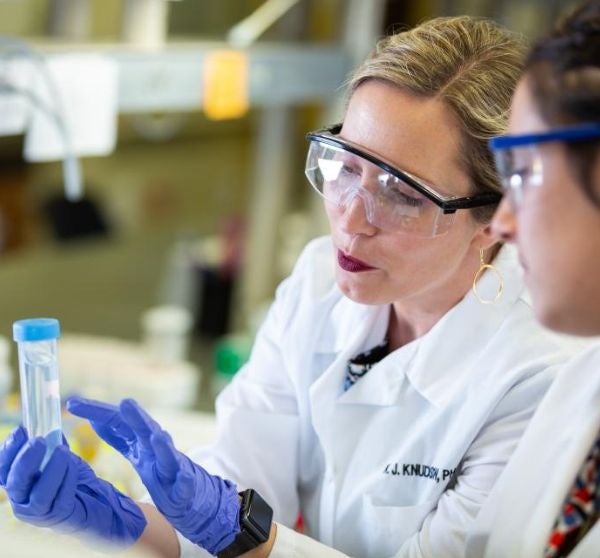 two people looking at a test tube in a lab environment